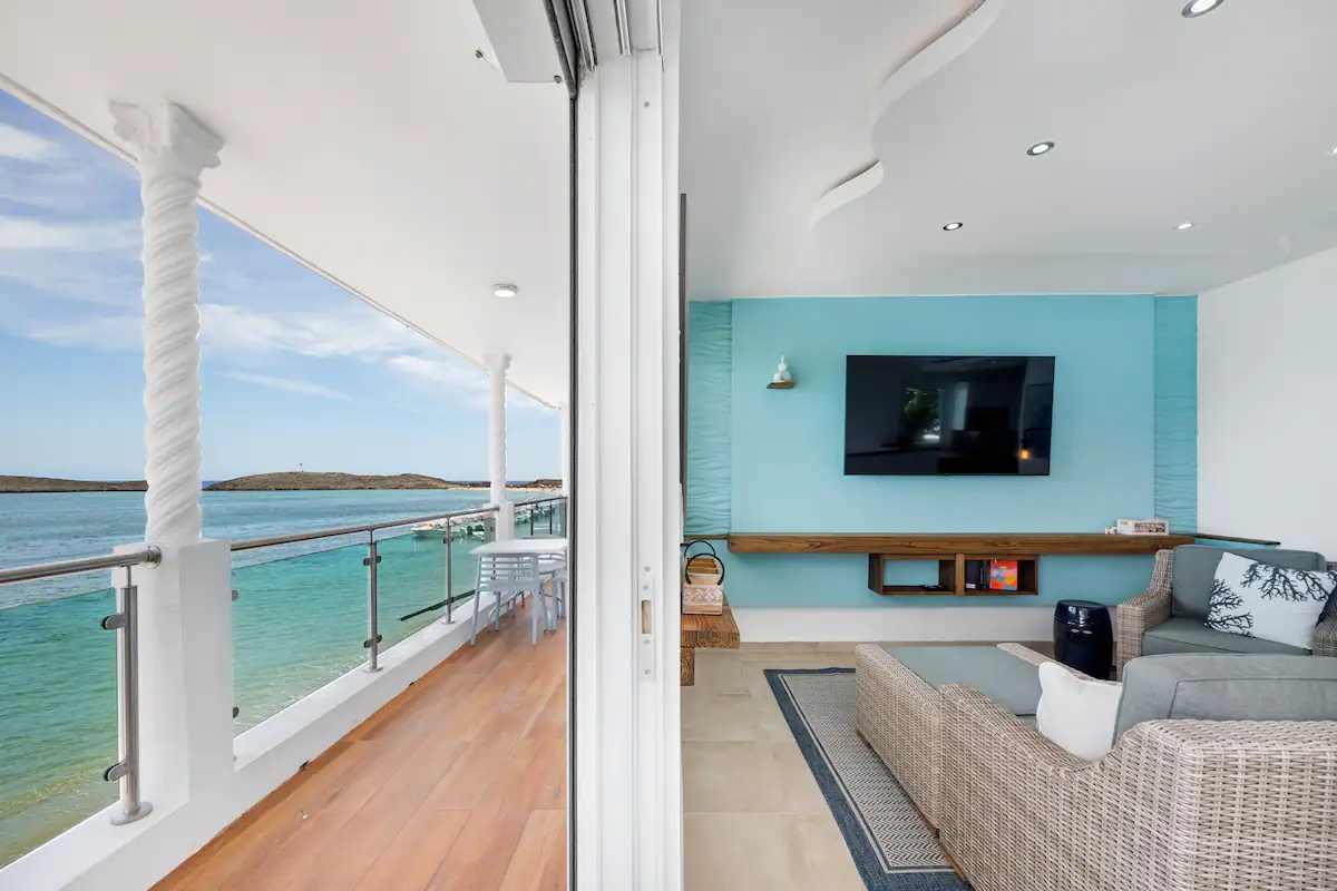 Sala con pared aqua abierta al balcón y al mar